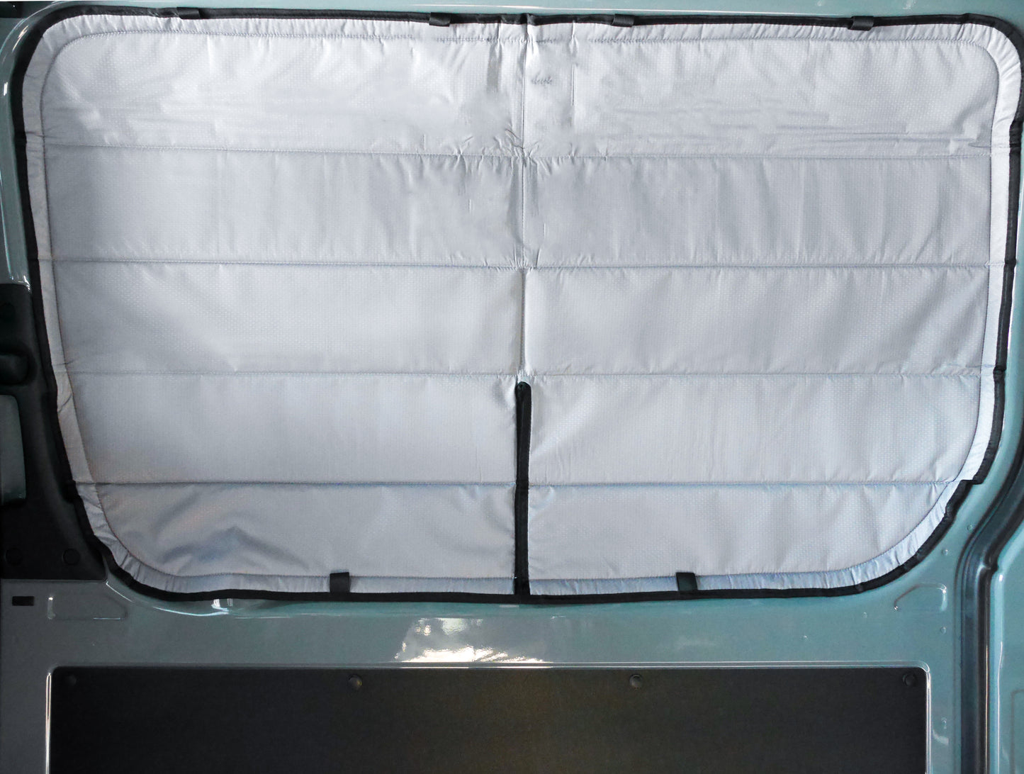 Image of the cover seamlessly attached to a sliding door window in a Sprinter van, showcasing a perfect fit and sleek installation.