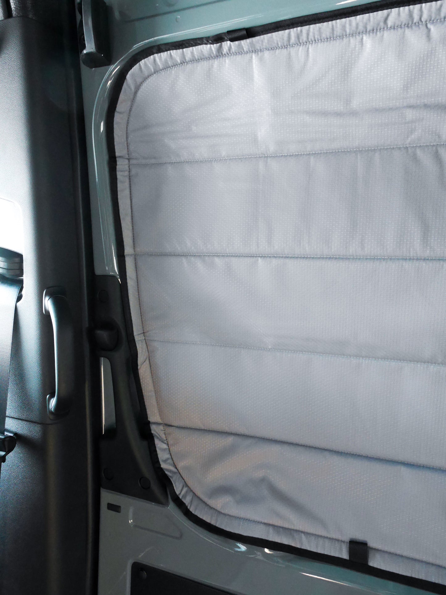 Image of the cover seamlessly attached to a sliding door window in a Sprinter van, showcasing a perfect fit and sleek installation.