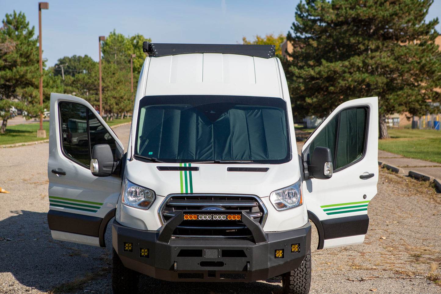 Image of a Ford Transit van viewed from the outside, with front cab window covers securely in place, providing complete coverage and a sleek appearance.