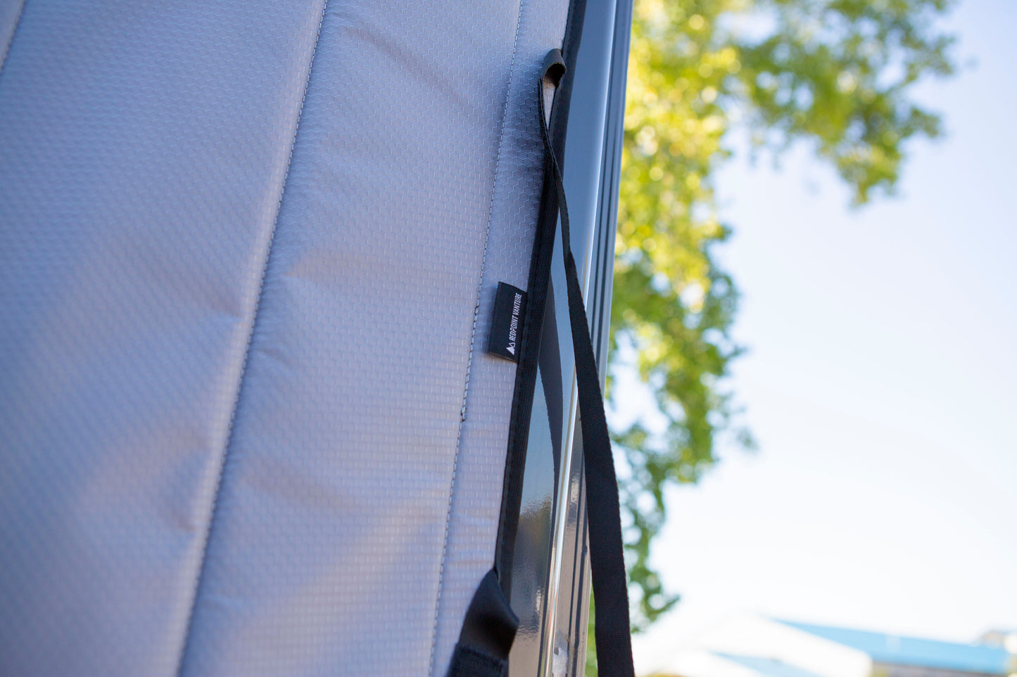 Close-up image of the Redpoint Van Parts logo tag "redpoint vanture" on the front door window cover, highlighting its high-quality material and precise design for a secure, seamless fit on the front door window.