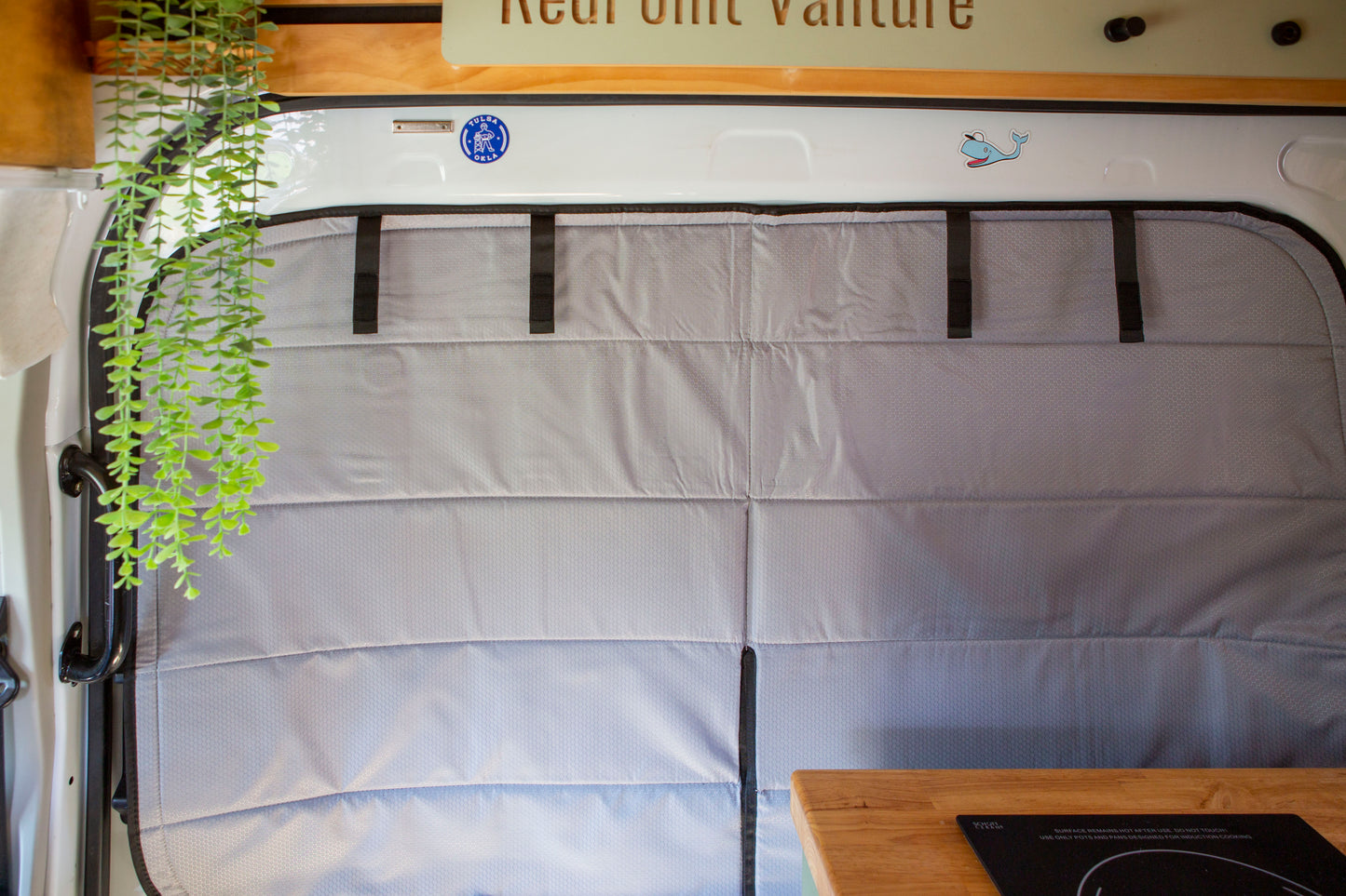 Image of the cover seamlessly attached to a sliding door window in a camper van, showcasing a perfect fit and sleek installation.