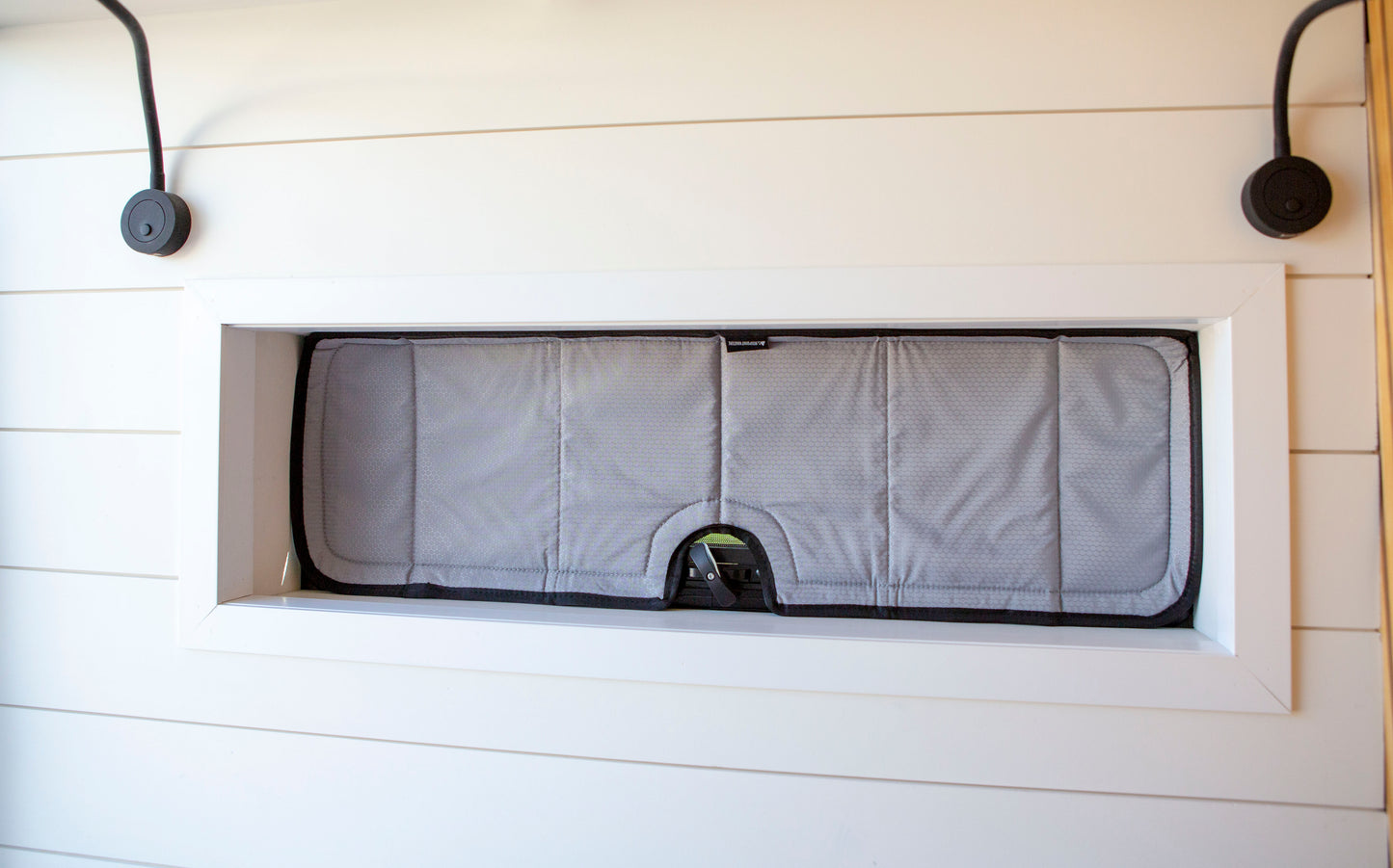 Image of the cover seamlessly attached to a bunk window in a camper van, showcasing a perfect fit and sleek installation.
