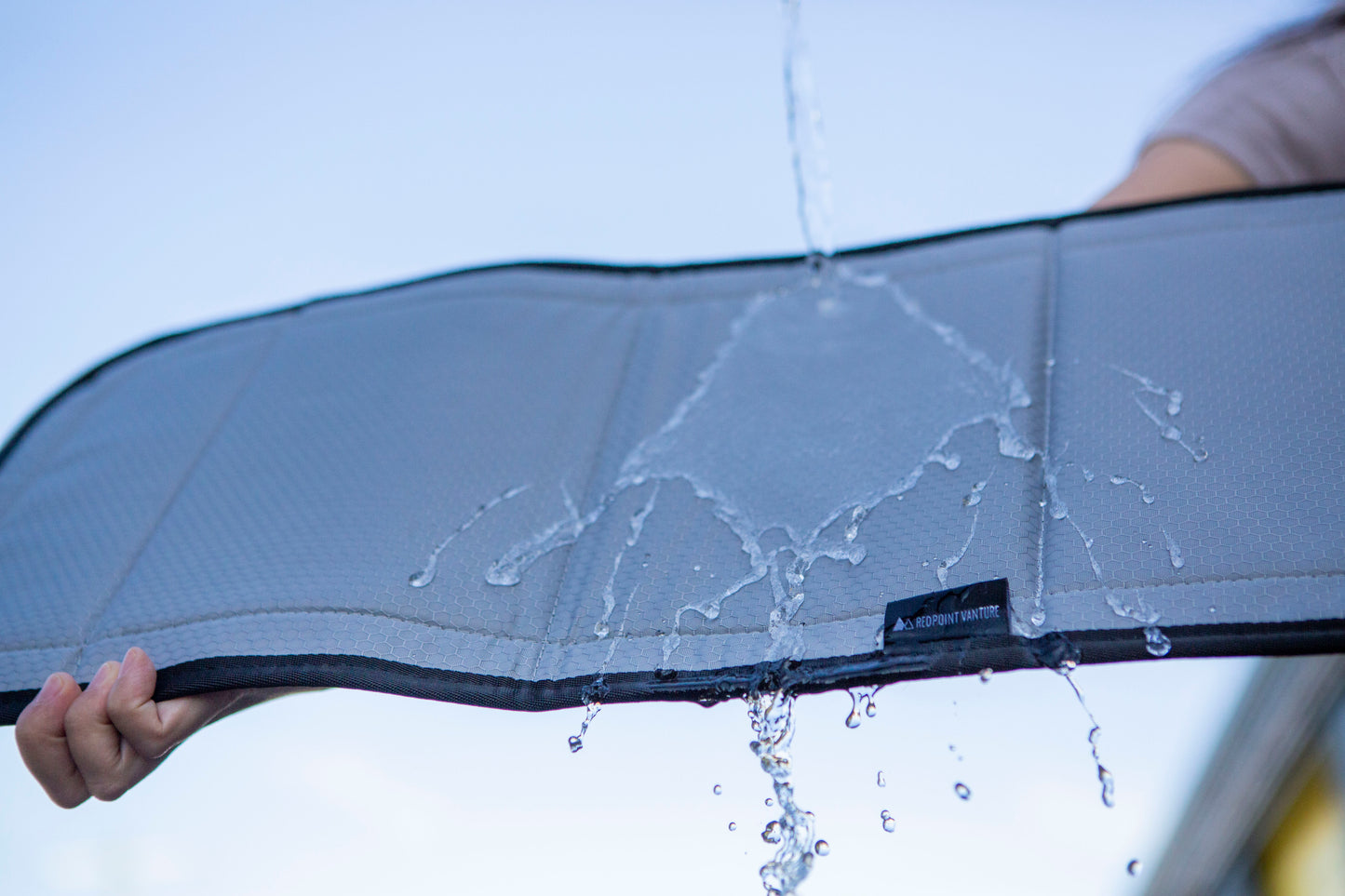 Insulated black-out bunk window cover for CRL & VWD windows demonstrating its water resistant feature