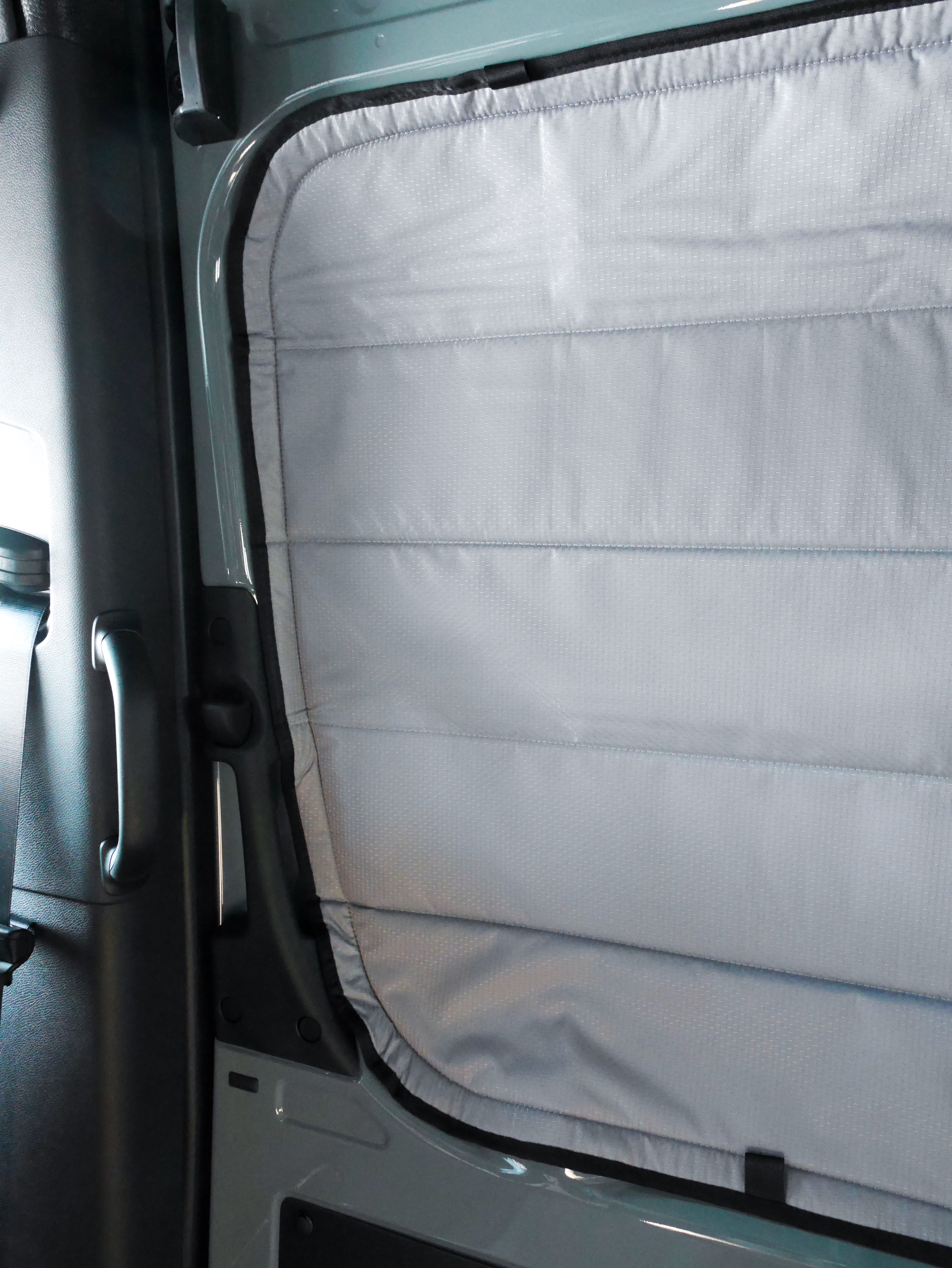 Image of the cover seamlessly attached to a sliding door window in a Sprinter van, showcasing a perfect fit and sleek installation.