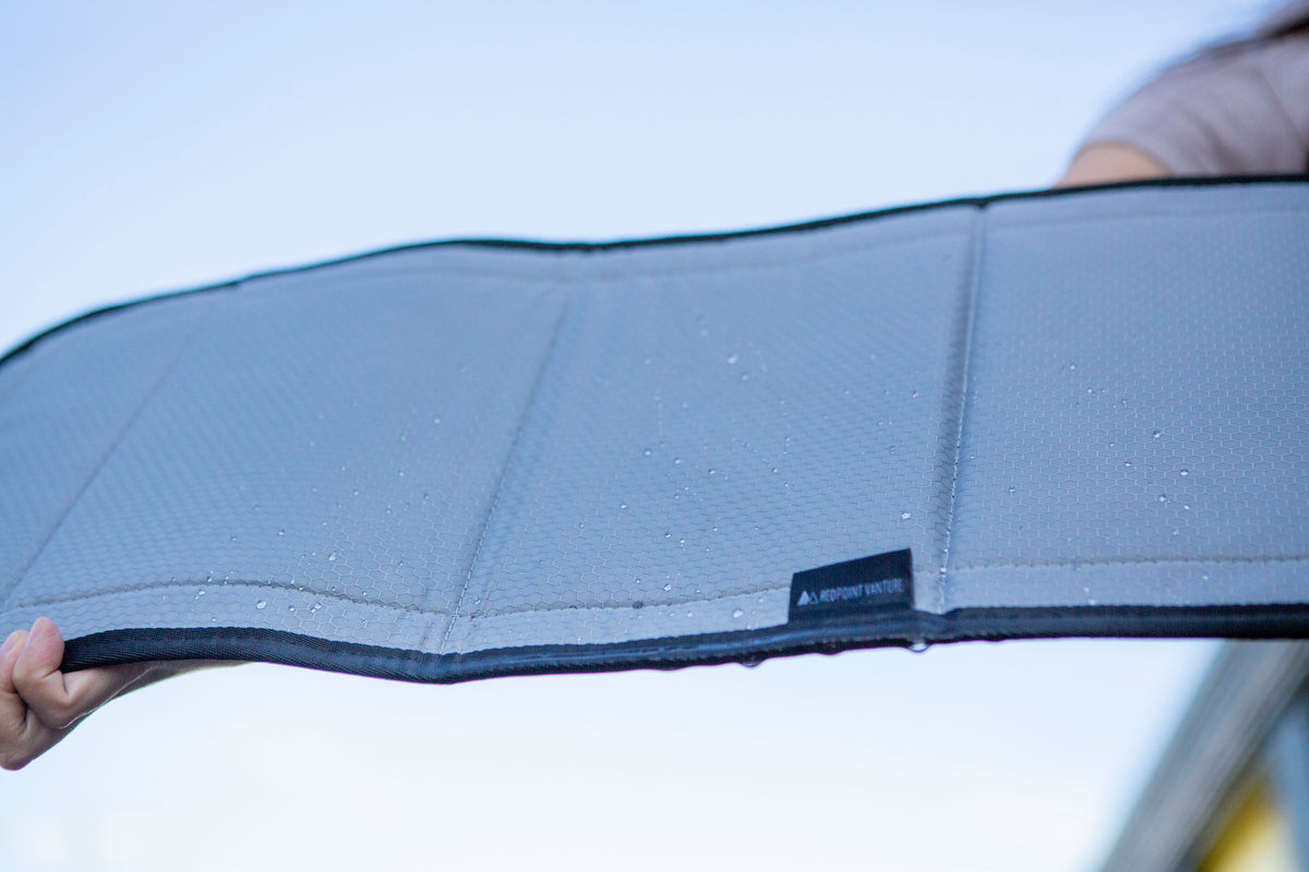 Image of the window cover after water has poured over it, with water droplets remaining on its dry surface, showcasing its water-resistant feature.